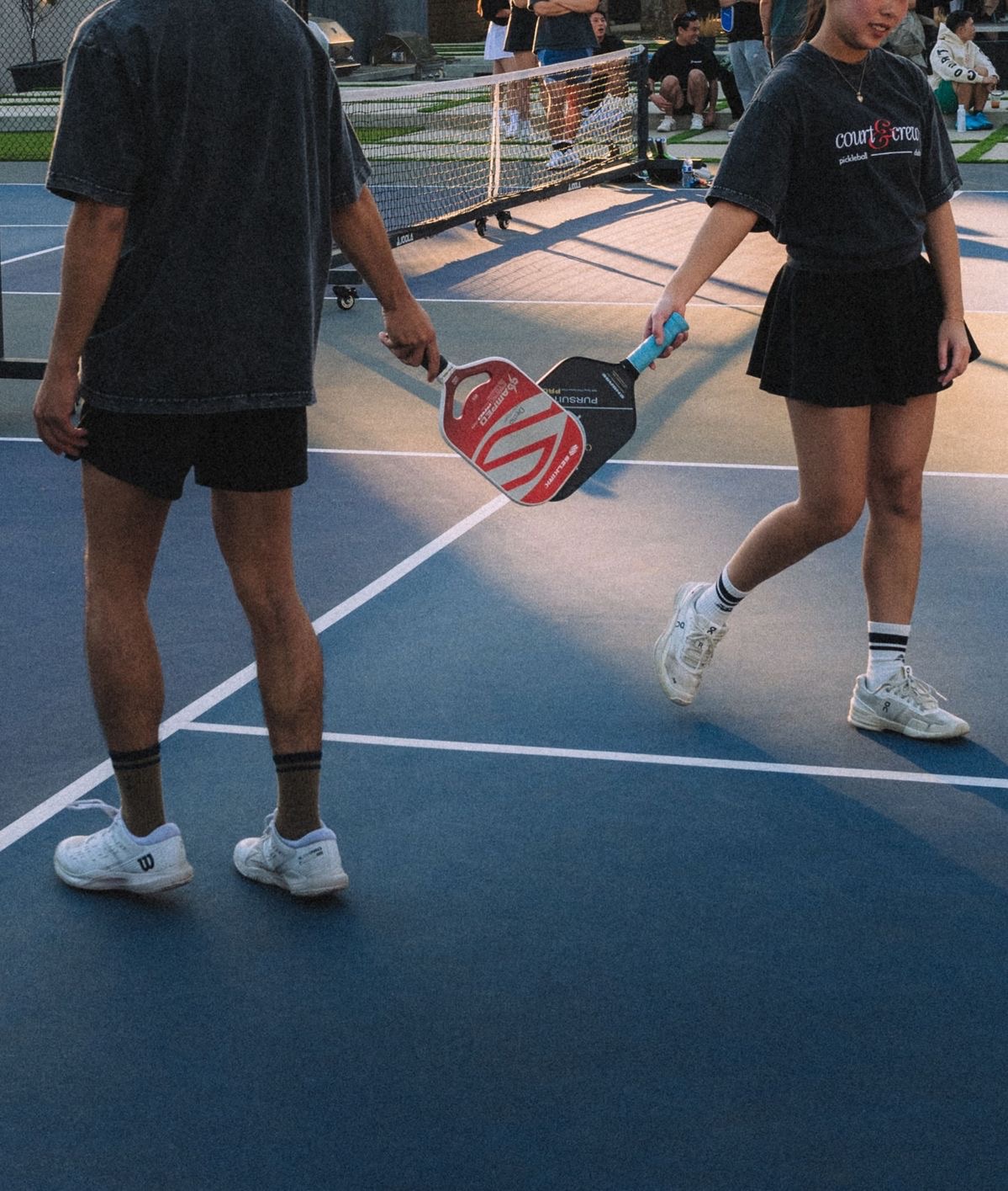 Zwei Pickleball-Spieler klatschen sich mit den Schlägern ab